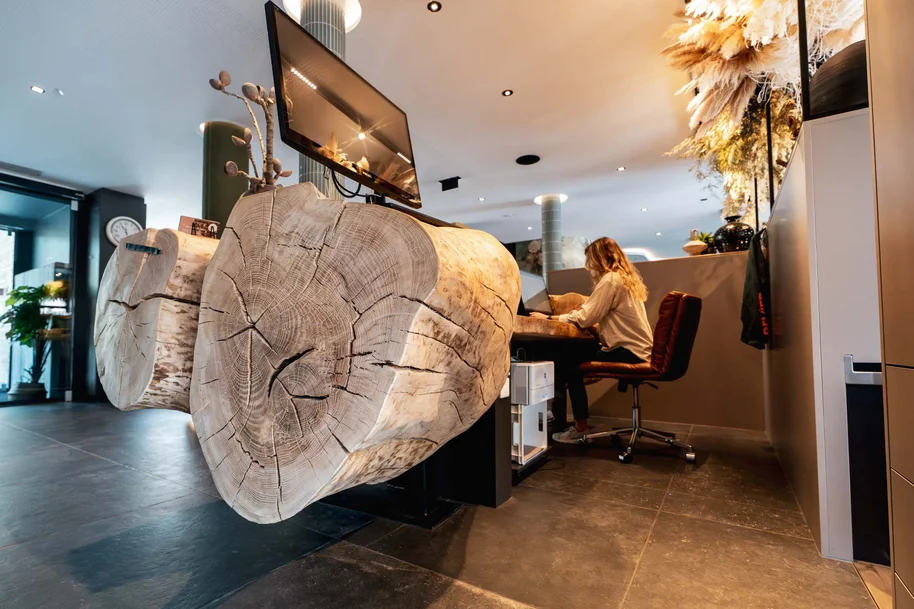 Baumstamm Rezeption als hochwertiges Gestaltungselement in einer modernen Hotelrezeption