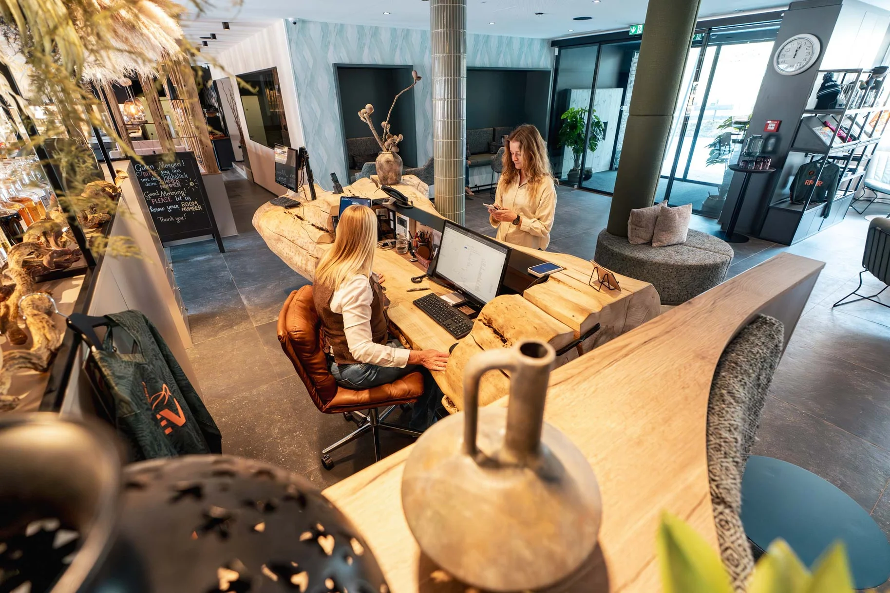 Empfangstheke aus massivem Holz mit natürlicher Baumkante in einer modernen Hotel-Lobby