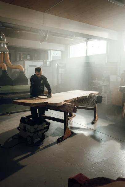 Scatto d'atmosfera dell'interno del laboratorio Stammdesign con un collaboratore al banco di lavoro