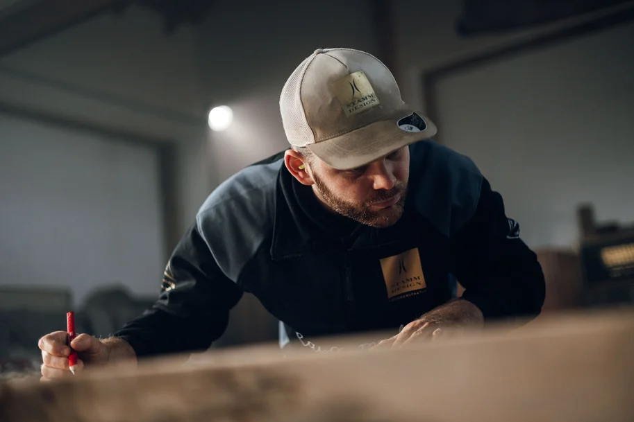 Un collaboratore traccia dei segni su un pezzo di legno con una penna