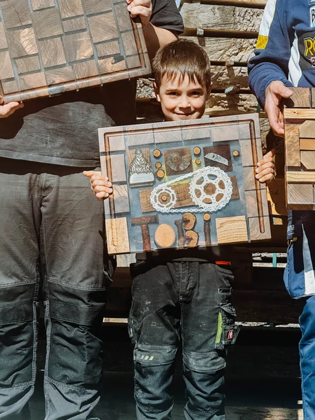 Junge zeigt stolz sein eigenes Schneidebrett mit der Inschrift „Tobi“