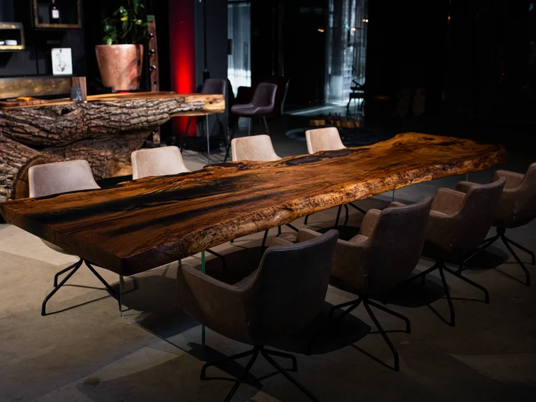 Table moderne en tronc de chêne avec bord naturel et pieds en verre transparent comme table à manger pour huit personnes