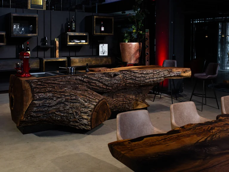 Cuisine sur mesure réalisée à partir d’un tronc massif de noyer avec bord naturel dans un loft de style industriel